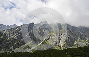 Scénický pohled na skalnaté mlžné hory proti zatažené obloze ve Vysokých Tatrách, Slovensko