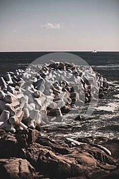 Scenic view of a rugged coastline with a line of small waves rolling in against the frozen rocks