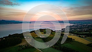 Scenic view of rural houses on green hills near Lake Geneva in Lausanne, Switzerland at sunset