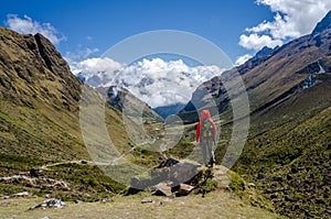 Scenic view on the Salkantay trek in Peru, woman in red jacket admiring the view