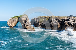 Scenic view of sea against blue sky in rocky coast photo