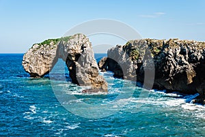 Scenic view of sea against blue sky in rocky coast photo