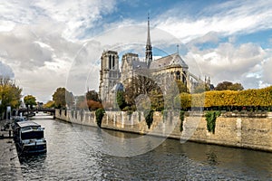 A scenic view of Seine river embankment and Notre-Dame de Paris cathedral in autumn season, Paris
