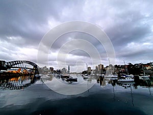 Scenic view of the Sidney harbor with its bridge yatchs ona gloomy weather photo