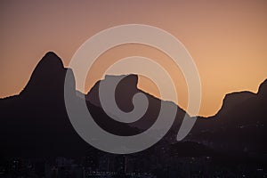 Scenic view of a silhouette of mountains and modern buildings in Rio de Janeiro at sunset