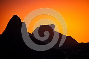 Scenic view of a silhouette of mountains and modern buildings in Rio de Janeiro at sunset