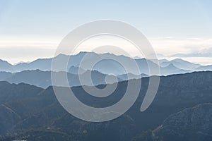 Scenic view of silhouettes of mountains in the morning mist