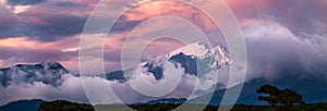 Scenic view of snow capped mountain peak against sky. Sunset, panoramic version.