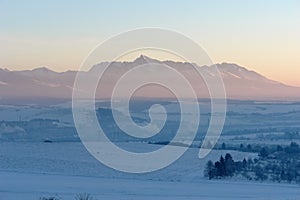 Scenic view of snow-covered fields and sunrise in the High Tatras mountains.