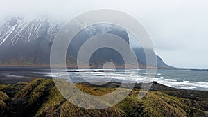 Scenic view of Stokksnes cape and Vestrahorn Mountain covered in fog in Iceland.