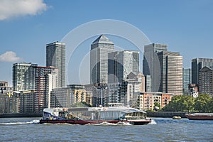 Scenic view on a sunny day with blue skies with water reflections on Office buildings, skyscrapers, River Thames, yacht, marina