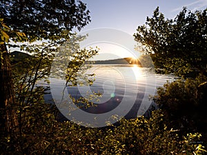 Scenic view of the sunset scene over the mountains around a calm lake in the forest