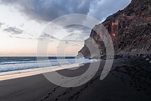 Scenic view during sunset on the volcanic sand beach Playa del Ingles in Valle Gran Rey, La Gomera. Footprint in sand photo