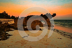 Scenic view of sunset at Watamu Beach seen through a hole on a coral rock in Watamu, Kilifi County, Kenya