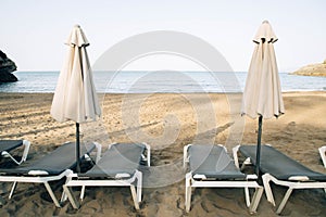 Scenic view to a chaise lounges and umbrellas on the sandy beach