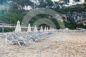 Scenic view to a chaise lounges and umbrellas on the sandy beach without people