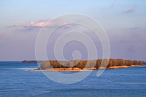 Scenic view to river island illuminated by sunset. Dnieper river near Cherkasy, Ukraine