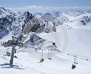 Scenic view from top of Wildspitz on winter landscape with snow covered mountain slopes and pistes and skiers on chair