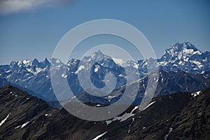 Scenic view of towering snow-covered mountains against a serene blue sky backdrop