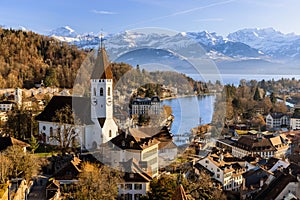 Scenic view of traditional buildings surrounding the tranquil Thun lake in Switzerland in autumn