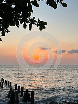 Scenic view of a tranquil pier in the ocean at sunset