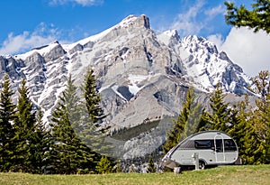 Scenic view of Tunnel mountain in Banff, Alberta with a small teardrop camper trailer in front.