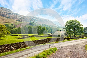 Scenic view of a valley with a country road in the foreground at the sunny day in Lake District National Park, Cumbria, England, U