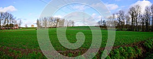 Scenic view of vast green rolling fields against the blue sky