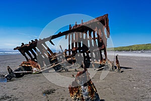 Scenic view of a vintage shipwreck on the Oregon coast near the tranquil body of water