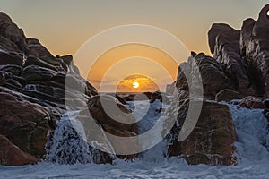 Scenic view of a waterfall and rocky outcrop on the horizon at sunset in Yallingup, Australia