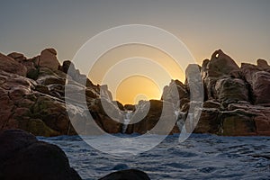 Scenic view of a waterfall and rocky outcrop on the horizon at sunset in Yallingup, Australia