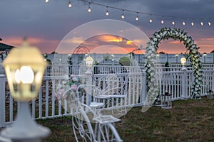 Scenic view of a wedding venue decorated with beautiful flowers with a sunset in the background