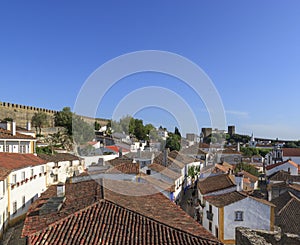 Scenic view of white houses red tiled roofs, and castle from wall of fortress. Beautiful old town with medieval. Obidos village,