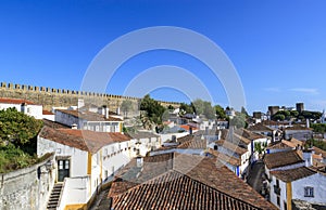 Scenic view of white houses red tiled roofs, and castle from wall of fortress. Beautiful old town with medieval. Obidos village,