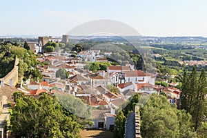 Scenic view of white houses red tiled roofs, and castle from wall of fortress. Beautiful old town with medieval. Obidos village,