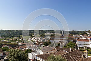 Scenic view of white houses red tiled roofs, and castle from wall of fortress. Beautiful old town with medieval. Obidos village,