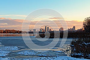 Scenic view of willow trees and poplars close to the frozen Dnieper River in Kyiv during sunset in winter