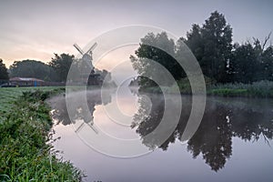 Windmill by the River on a Misty Morning