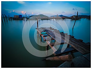 Scenic view of wooden posts against sky during sunset