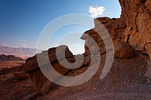 Scenic weathered orange rock in stone desert on su