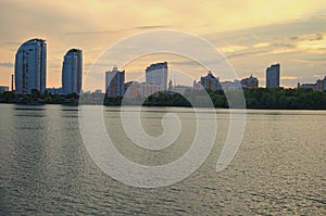 Scenic wide-angle landscape of Obolon neighborhood during sunset. High-rise Buildings along embankment of Dnieper river in Kiev.