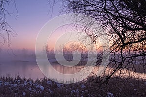 Scenic winter landscape with a lake at sunset