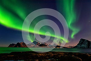 Scenic winter landscape with northern lights, Aurora borealis in night sky, Lofoten Islands, Norway