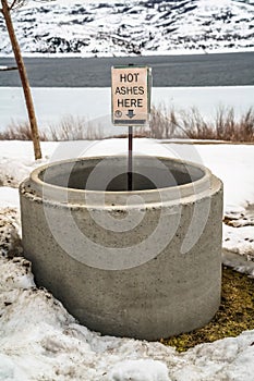 Scenic winter landscape at a park with close up of a circular pit with ashes