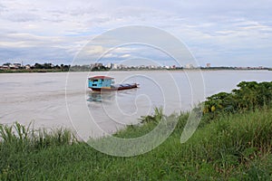 Scenics of the Mekong river in the cloudy day with cargo ship.