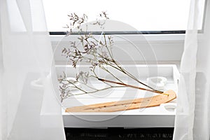 Scent Styling concept. Home window sill with incense candle burning on white.