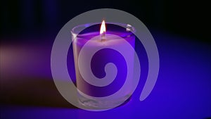 Scented candle burning in purp