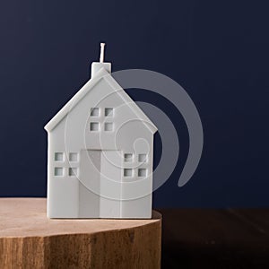 Scented candle in the form of a house on a wooden stand