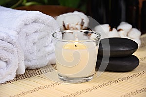 Scented candle, massage stones and white towels spa still life stock photo images