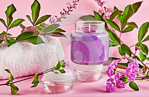 Scented candle for Spa and home with lavender scent and green leaves on a pink background